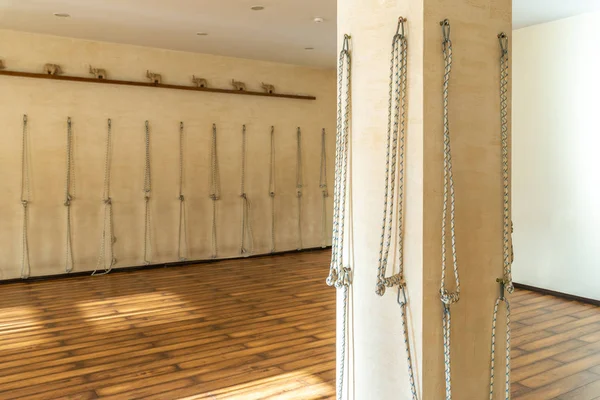 Cuerdas de yoga colgadas en la pared del estudio. Apoyos de yoga Iyengar — Foto de Stock