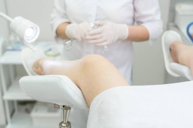 Beyaz üniformalı jinekolog vajinal spekulumla hastanede.