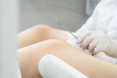 Jinekolog ameliyattan önce dikiş atmak için iğne tutuyor.