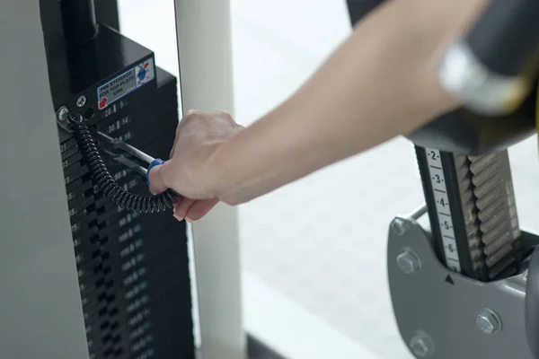 Weight adjustment on training equipment at a gym. Separating weight for adjusting to size and strength — 스톡 사진