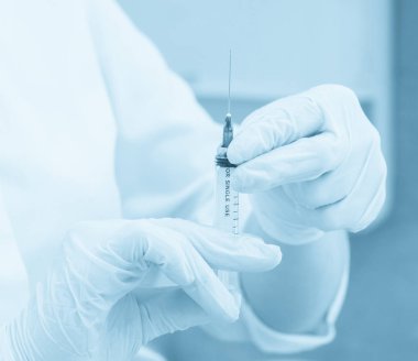 Sağlık sigortası. Şırıngalı doktor, hastanede iğne, mavi tonlama.