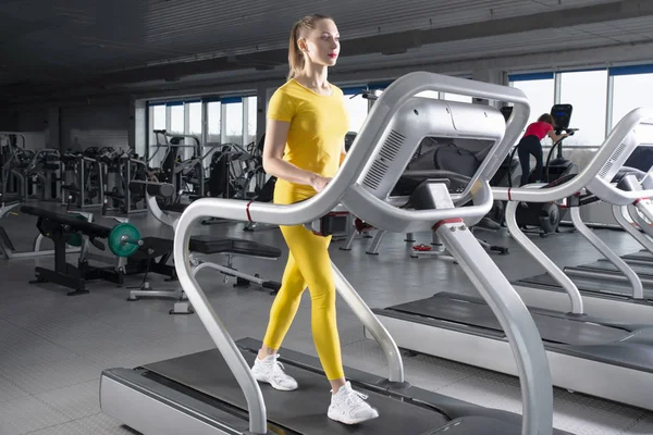 Young woman walking on treadmill in gym — Stock Photo, Image