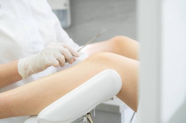 Jinekolog ameliyattan önce dikiş atmak için iğne tutuyor.