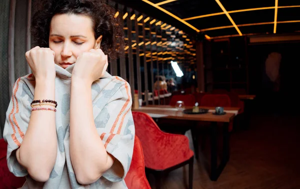 Üzgün, gözleri kapalı bir kız Kafe 'de masanın yanında dikiliyor. — Stok fotoğraf