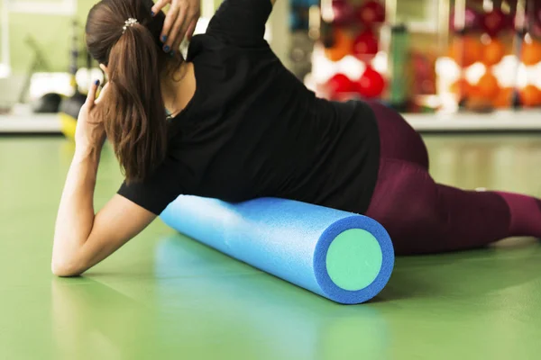 Kvinna som gör skumroller motion på ett golv i gymmet — Stockfoto