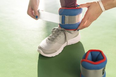 Spor, sağlık ve spor salonunda çalışmaya başlamadan önce bileklik takan bir kadın.