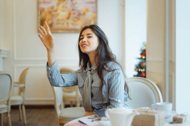Genç Asyalı kadın kafedeki garsonu arıyor.