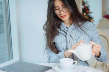 bir kafede çay ile oturan genç ve güzel kadın