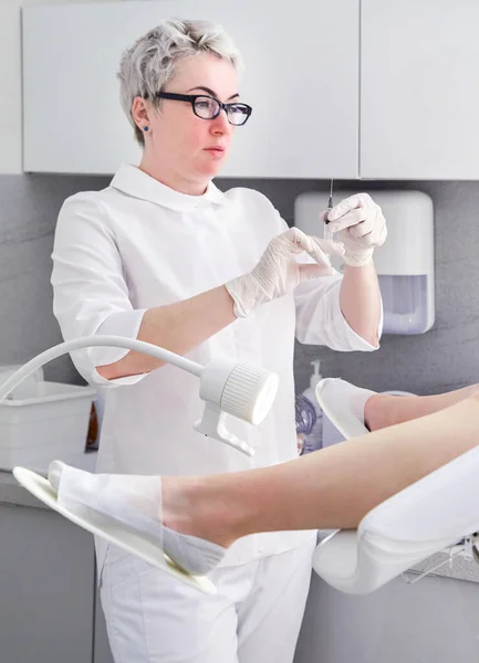 Gynaecoloog met injectiespuit injecteert de patiënt in een gynaecologiestoel — Stockfoto