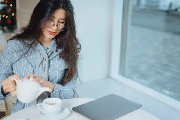 Çekici genç bir kadın kafede dinleniyor ve çay içiyor. — Stok fotoğraf