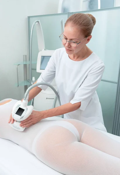 특별 한 흰색 양복을 입은 여성 이 스파 살롱에서 항 세포 성 마사지를 받고 있습니다. LPG, 그리고 클리닉에서 신체와 겨루는 치료. — 스톡 사진