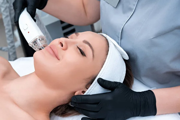 Mujer joven recibiendo tratamiento con láser en clínica de cosmetología —  Fotos de Stock