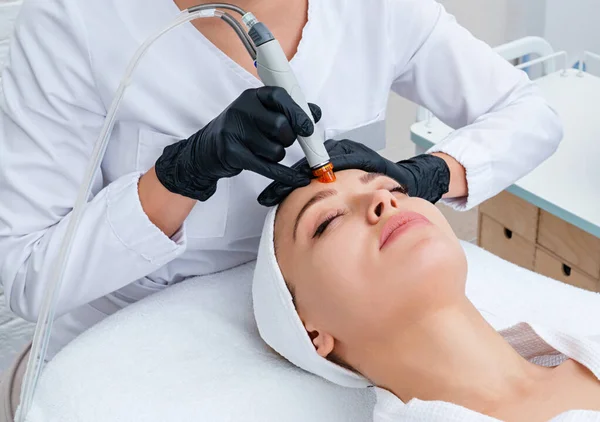Pielęgnacja Twarzy. zbliżenie kobiety oczyszczanie twarzy w klinice kosmetologii, odkurzanie — Zdjęcie stockowe