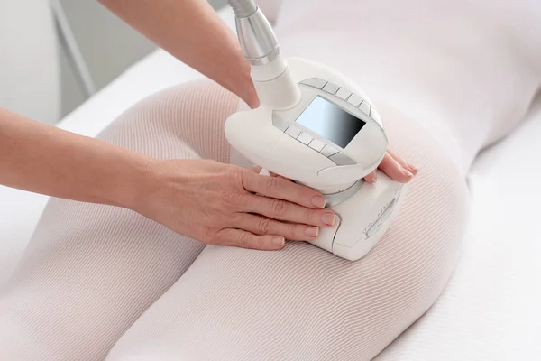 Frau in speziellem weißen Anzug lässt sich in einem Wellness-Salon gegen Cellulite massieren. LPG und Körperkonturbehandlung in der Klinik. — Stockfoto