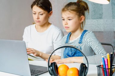 Anne ve kız birlikte ödev yapıyor, tasarım ve öğrenme konsepti, okul için görevler yapıyor.