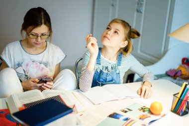 Anne ve kız birlikte ödev yapıyor, tasarım ve öğrenme konsepti, okul için görevler yapıyor.