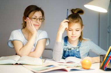 Anne ve kız birlikte ödev yapıyor, tasarım ve öğrenme konsepti, okul için görevler yapıyor.