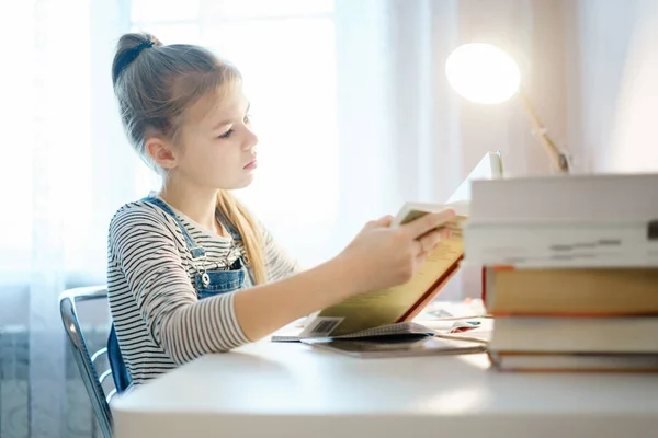 Adolescente haciendo la tarea en la mesa en casa preparándose para la prueba escolar —  Fotos de Stock