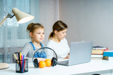 Anne ve kızı okul için ödev yapıyor. Eğitim konsepti.