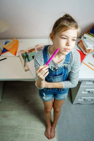 Adolescente debout près de la table et rêvant d'avoir une pause de faire des devoirs — Photo