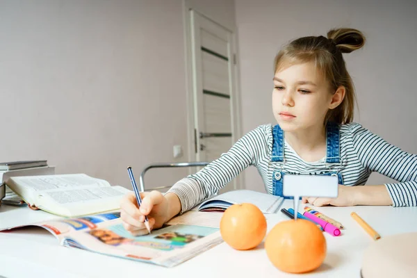 Ragazza adolescente che fa i compiti a tavola a casa preparandosi per il test scolastico — Foto Stock