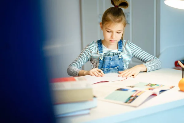 Красива дівчина працює над своїм шкільним проектом вдома, концепція освіти — стокове фото