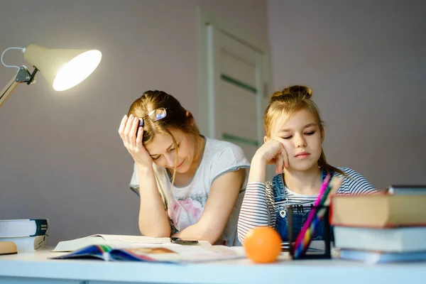 Yorgun kızı evde ev ödevlerinde yardımcı anne. — Stok fotoğraf