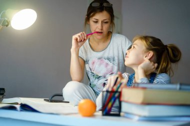 Mutlu Genç Anne, kızına yardım ederken okula hazırlanıyor.