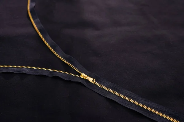 Open golden zipper on black fabric, tailor background — Stock Photo, Image