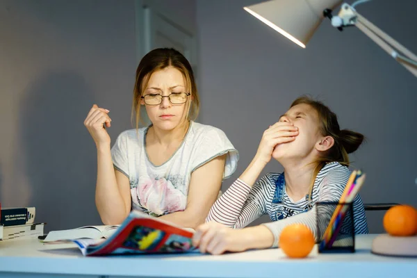 Yorgun kızı evde ev ödevlerinde yardımcı anne. — Stok fotoğraf