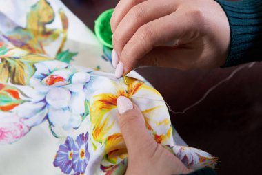 Terzi atölyede boncuk dekorasyon elbisesi kullanıyor.