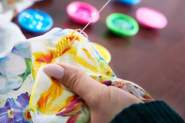 Terzi atölyede boncuk dekorasyon elbisesi kullanıyor.