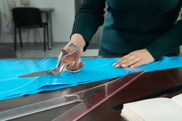 Dressmaker cięcia niebieskiej tkaniny w studio krawieckim, sklep atelier — Zdjęcie stockowe