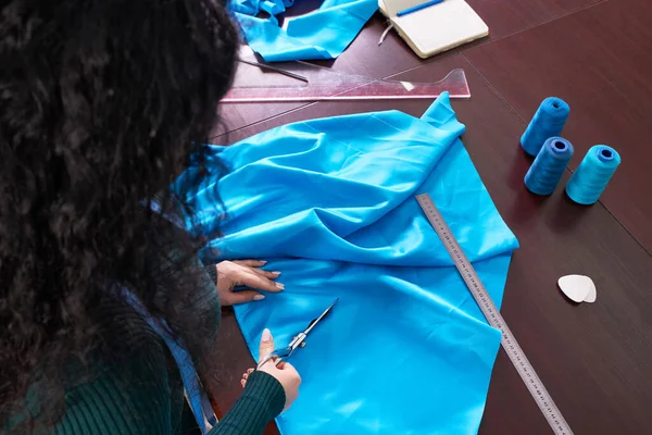 Dressmaker cutting blue fabric in tailor studio, atelier shop — Stock Photo, Image