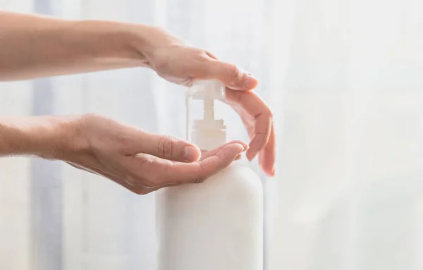 Kadın elleri beyaz arka planda plastik sabun şişesi pompalıyor. — Stok fotoğraf