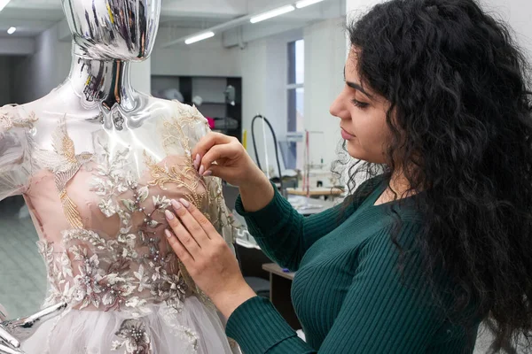 Dressmaker ustalania białej koronki sukni ślubnej na manekin w studio krawieckim — Zdjęcie stockowe
