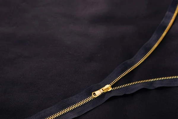 Fundo com zíper dourado aberto em tecido preto — Fotografia de Stock