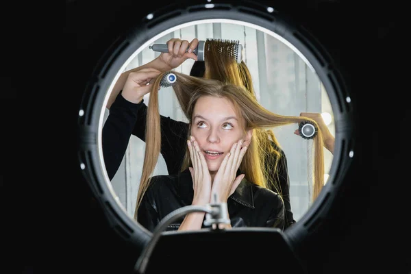 Egy nő egy szépségszalonban. Fogalmi fotó. Sok kéz csinálja a haját. — Stock Fotó