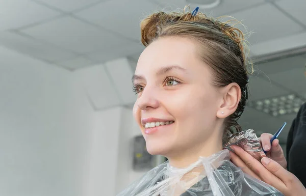 Kapper kleuren jonge vrouw haar met behulp van folie — Stockfoto