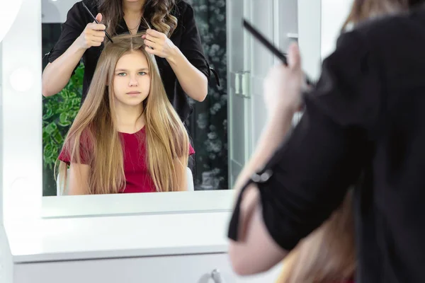 Peluquería haciendo un estilo de pelo a linda niña preadolescente — Foto de Stock