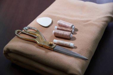 Tahta bir masanın üzerinde duran bir grup dikiş eşyası, terzi dükkânı konsepti