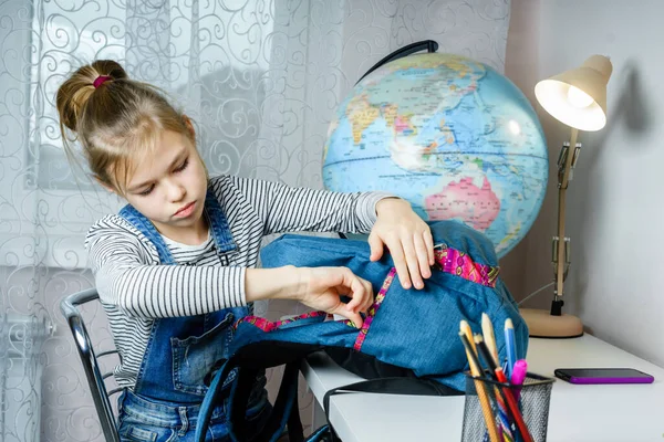 做完作业后，十多岁的女孩把东西装在背包里准备上学 — 图库照片