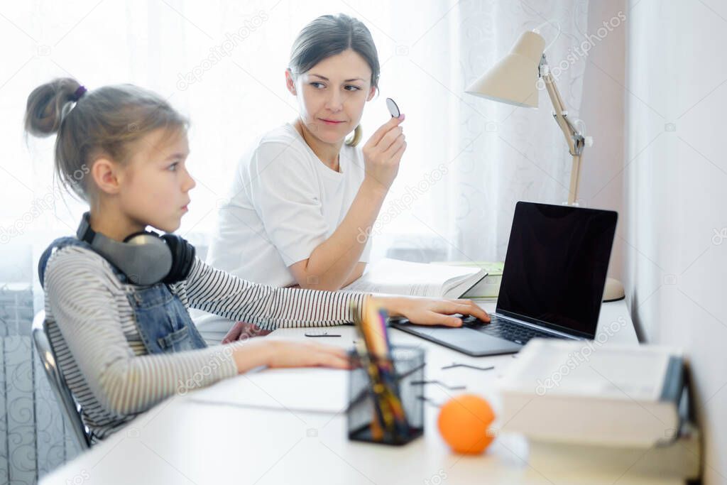 Mother and daughter doing homework together, styding and learning concept, doing tasks for school