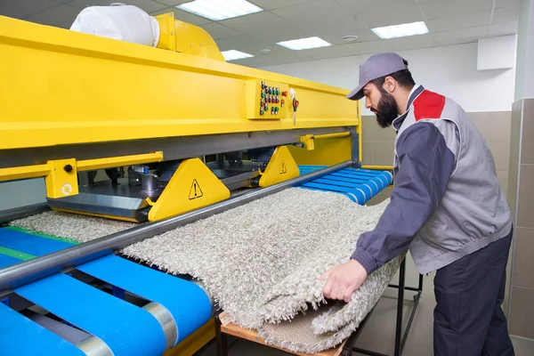 Pekerja binatu dalam proses bekerja pada mesin otomatis untuk mencuci karpet dalam dry cleaning — Stok Foto