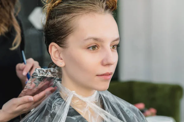 Fryzjer kolorowanki młoda kobieta włosy przy użyciu folii — Zdjęcie stockowe