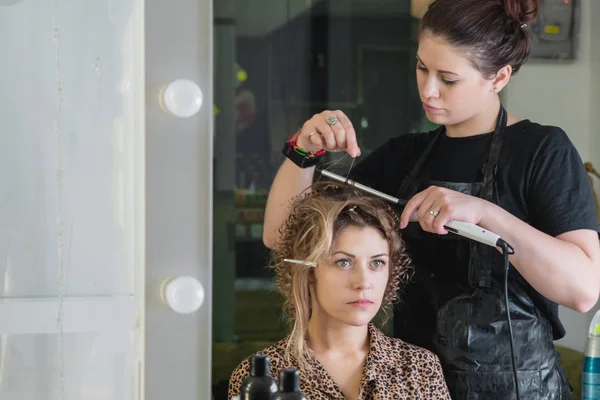 Fryzjer pracuje z piękną kobietą w salonie fryzjerskim. Zbliżenie widok dłoni, lokówka i urządzenia — Zdjęcie stockowe