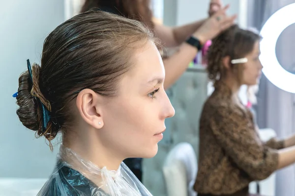 Fiatal lány, amelynek haj kezelés maszk egy szépségszalonban, fiatal lány ápolási folyamat során — Stock Fotó