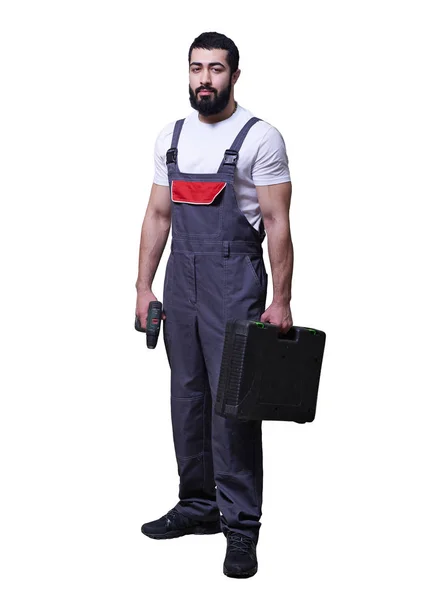 Worker wearing overalls standing and holding electric screwdriver or drill isolated on white background — Stock Photo, Image