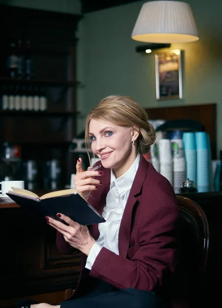 Kafede dizüstü bilgisayarı ve not defteriyle çalışan güzel bir iş kadını. — Stok fotoğraf