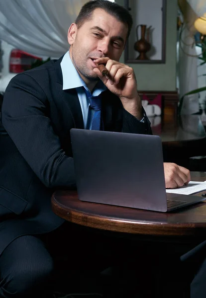 Uomo d'affari che lavora con documenti e laptop — Foto Stock